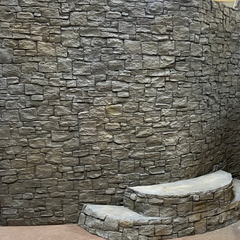 A Slow Curving Wall and Two Steps Leading towards Wall. The Wall and Steps are Covered with the Cobblestone Panel