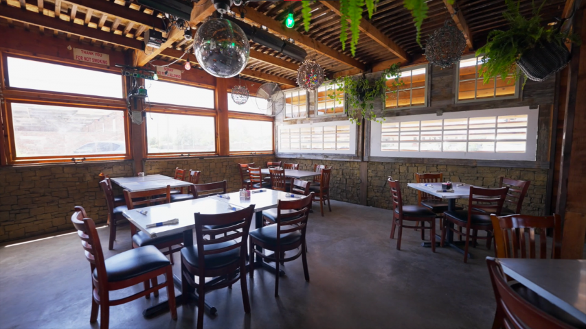 A restaurant with Large Windows above Walls covered by Large Cobblestone Panels
