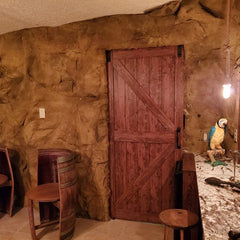 Malawi Panel on Bathroom Doorway Wall, a pair of barrel chairs to left of door, and a granite counter top to the right