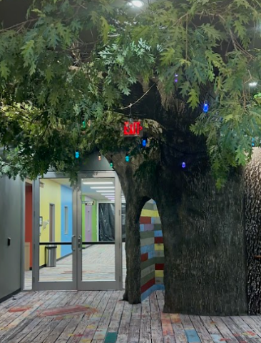 Large Faux Tree Entryway, With Pecan Panel mimicking bark. Above the Panel, Faux Leaves dangle in bunches