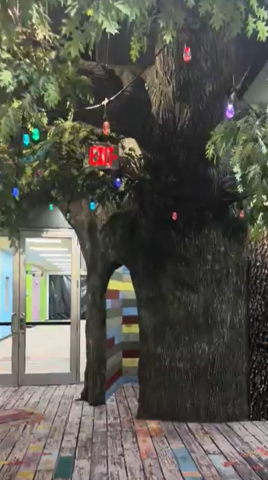 Large Faux Tree Entryway, With Pecan Panel mimicking bark. Above the Panel, Faux Leaves dangle in bunches